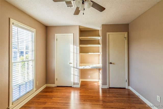 unfurnished bedroom featuring ceiling fan, hardwood / wood-style floors, and a textured ceiling