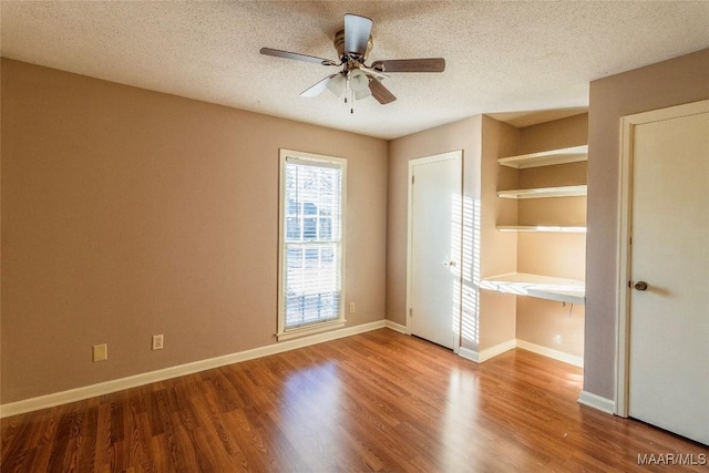 unfurnished bedroom featuring hardwood / wood-style floors, ceiling fan, and a textured ceiling