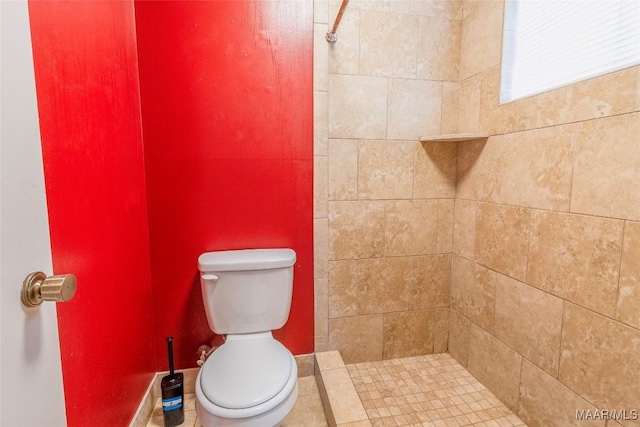 bathroom featuring toilet and a tile shower