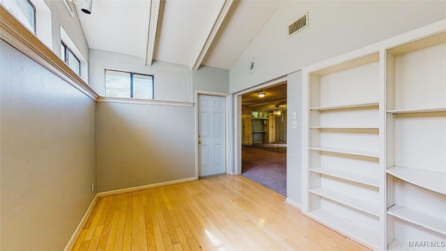 unfurnished room featuring beam ceiling, wood-type flooring, and high vaulted ceiling