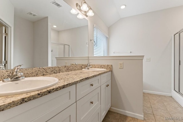 bathroom featuring tile patterned floors, vanity, a shower with door, and vaulted ceiling