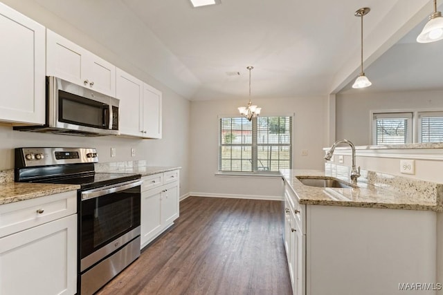 kitchen with appliances with stainless steel finishes, white cabinetry, hanging light fixtures, and sink