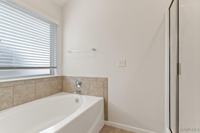 bathroom with tile patterned flooring and a bath