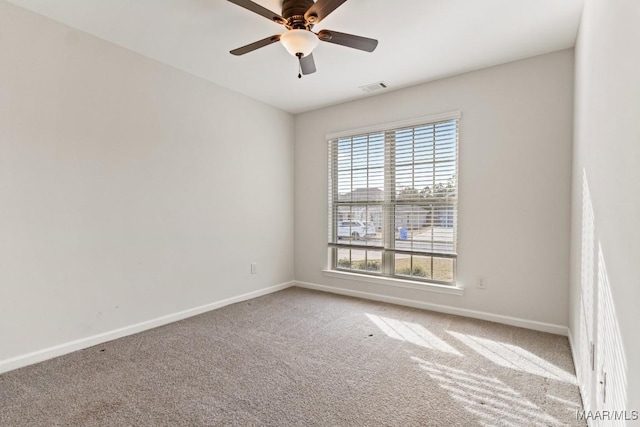 carpeted spare room featuring ceiling fan