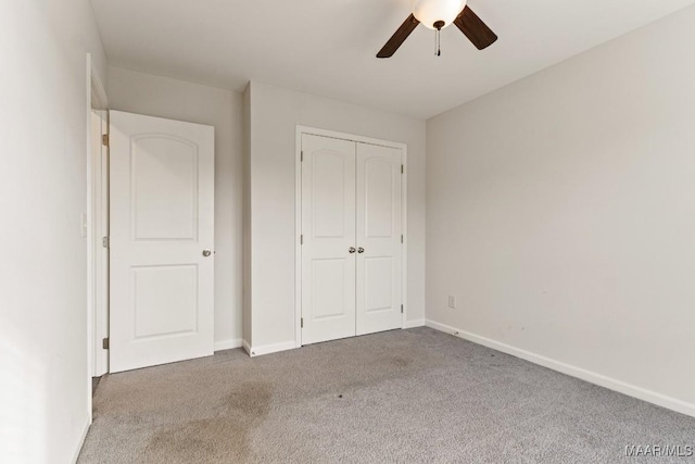 unfurnished bedroom with carpet, ceiling fan, and a closet