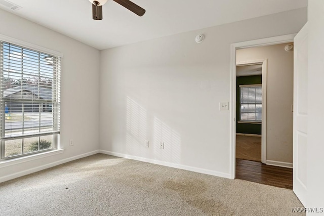 unfurnished room featuring carpet flooring, a wealth of natural light, and ceiling fan