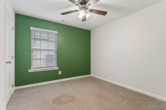 carpeted spare room featuring ceiling fan