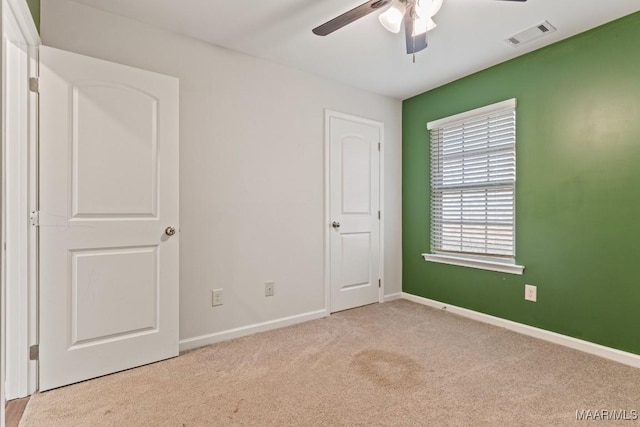 carpeted spare room with ceiling fan