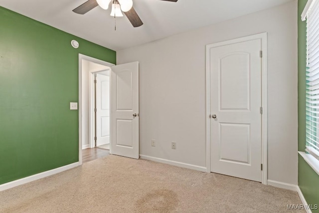 unfurnished bedroom featuring ceiling fan and light colored carpet