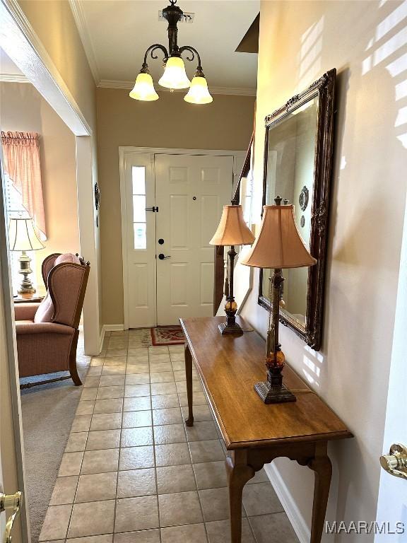 foyer entrance with crown molding and an inviting chandelier