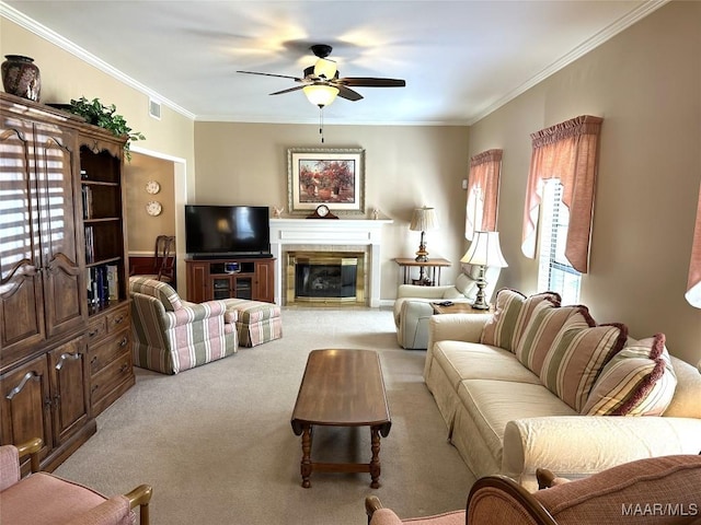 living room with a tile fireplace, light colored carpet, ceiling fan, and ornamental molding