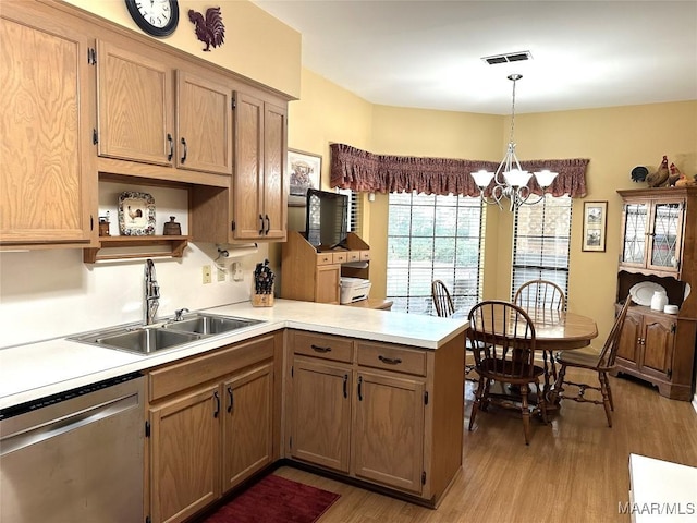 kitchen featuring pendant lighting, dishwasher, sink, light wood-type flooring, and kitchen peninsula