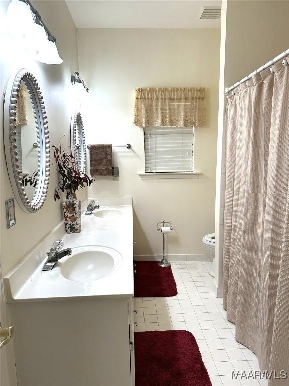 bathroom featuring tile patterned floors, vanity, and toilet