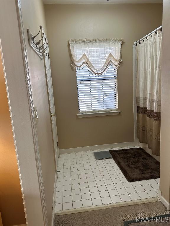 bathroom featuring tile patterned flooring and curtained shower