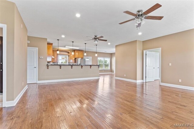 unfurnished living room with ceiling fan and light wood-type flooring