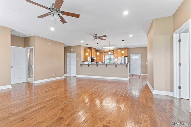 unfurnished living room with light hardwood / wood-style flooring and ceiling fan