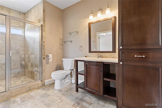 bathroom featuring backsplash, toilet, vanity, and walk in shower