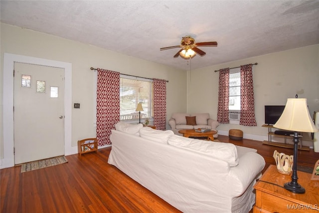 living room featuring a textured ceiling, dark hardwood / wood-style flooring, and ceiling fan