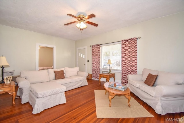 living room with ceiling fan and dark hardwood / wood-style flooring