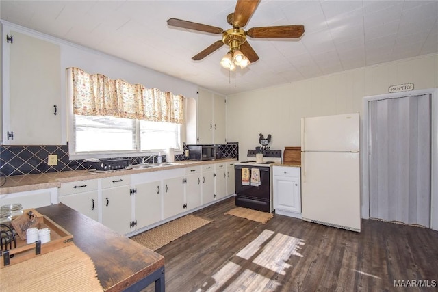 kitchen with dark hardwood / wood-style floors, white refrigerator, black range with electric stovetop, and white cabinetry