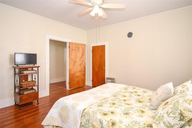 bedroom with ceiling fan, dark hardwood / wood-style floors, and ornamental molding