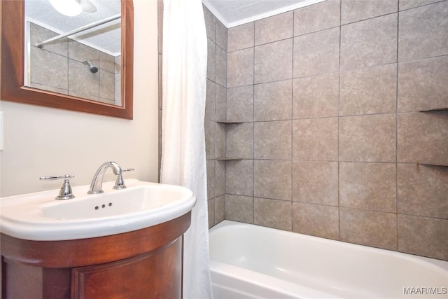 bathroom with vanity, shower / bathtub combination with curtain, a textured ceiling, and ornamental molding