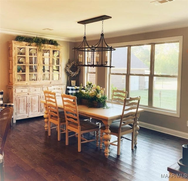 dining area featuring dark hardwood / wood-style flooring, crown molding, and a notable chandelier