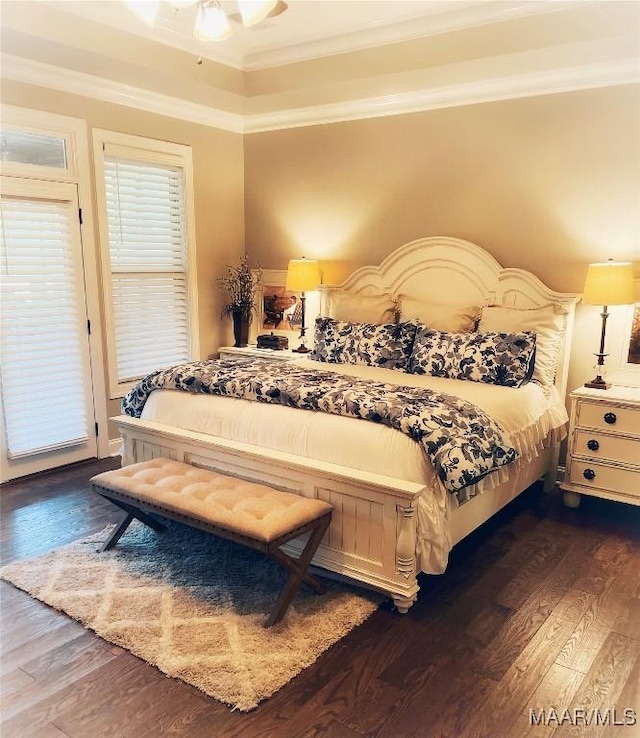 bedroom featuring ornamental molding, ceiling fan, and dark wood-type flooring