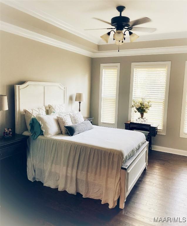 bedroom featuring ceiling fan, crown molding, and dark wood-type flooring