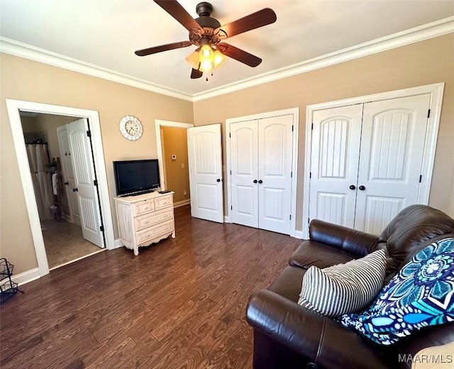 living room featuring dark hardwood / wood-style floors, ceiling fan, and ornamental molding