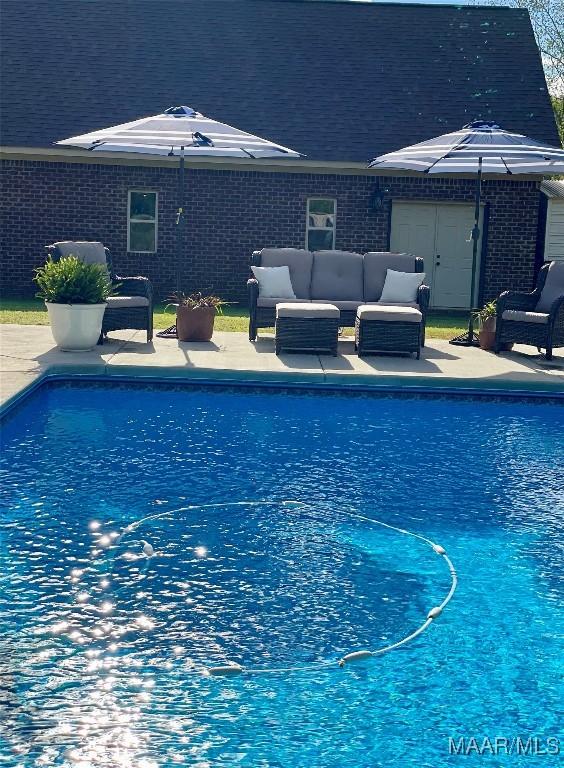 view of swimming pool featuring outdoor lounge area and a patio