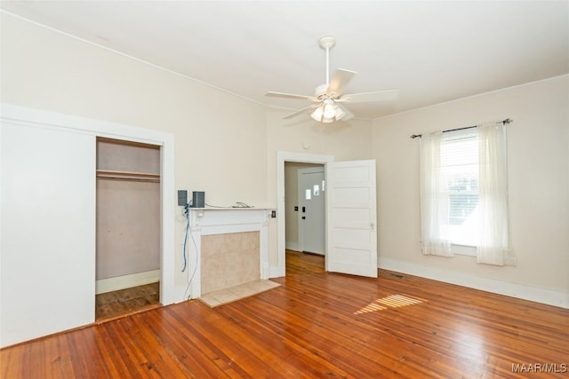 unfurnished bedroom featuring ceiling fan, a closet, and wood-type flooring