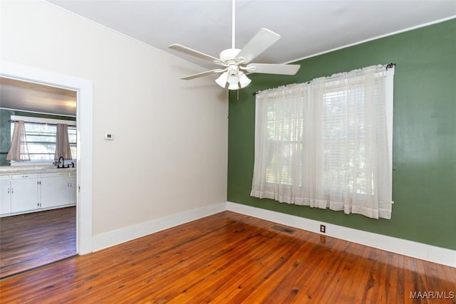 unfurnished room with hardwood / wood-style floors and ceiling fan