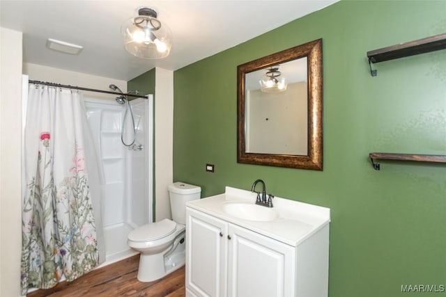 bathroom featuring wood-type flooring, vanity, toilet, and walk in shower