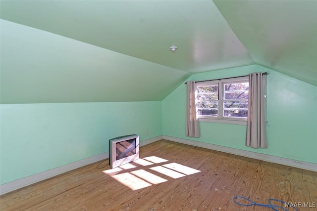 bonus room with light hardwood / wood-style floors and vaulted ceiling