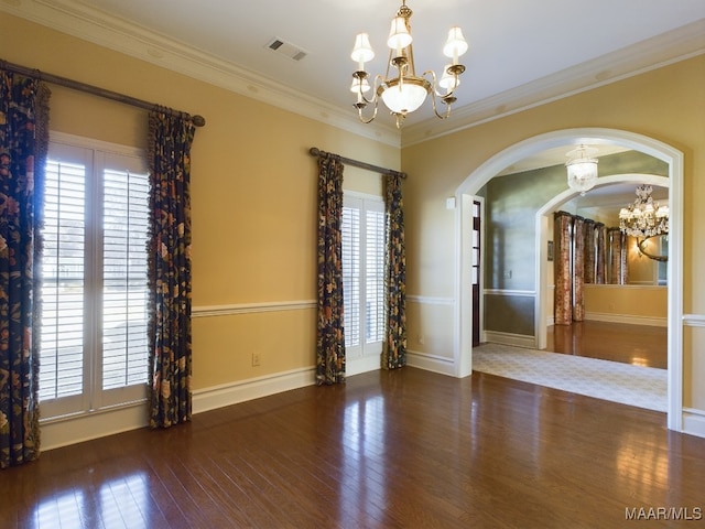 spare room featuring ornamental molding, dark hardwood / wood-style floors, and an inviting chandelier