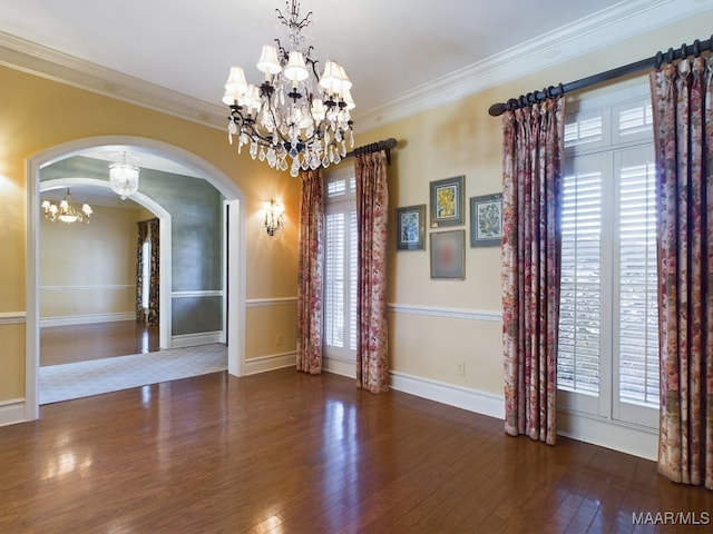 spare room featuring crown molding, plenty of natural light, and an inviting chandelier