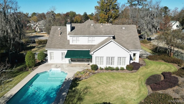 back of house featuring a fenced in pool, a patio area, and a yard