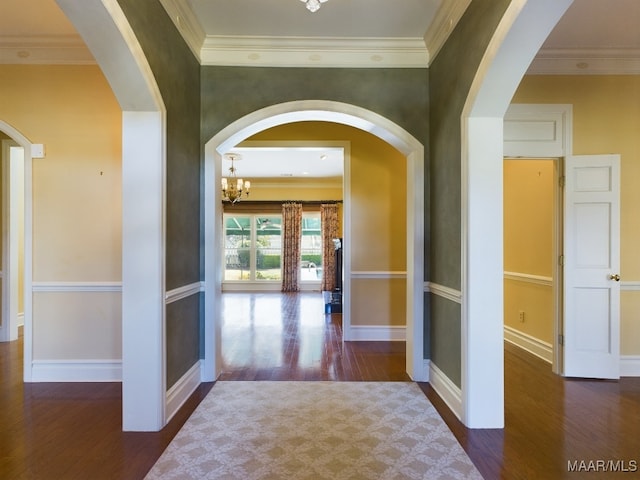 hall with dark hardwood / wood-style flooring, crown molding, and a notable chandelier