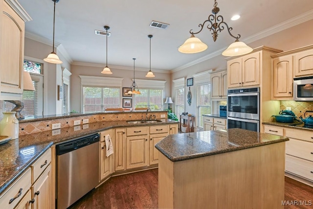 kitchen featuring sink, a center island, stainless steel appliances, light brown cabinets, and decorative light fixtures