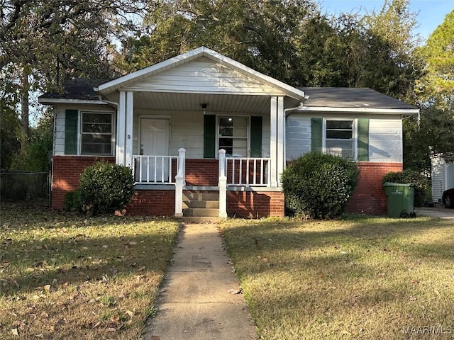 view of front of house with covered porch and a front lawn