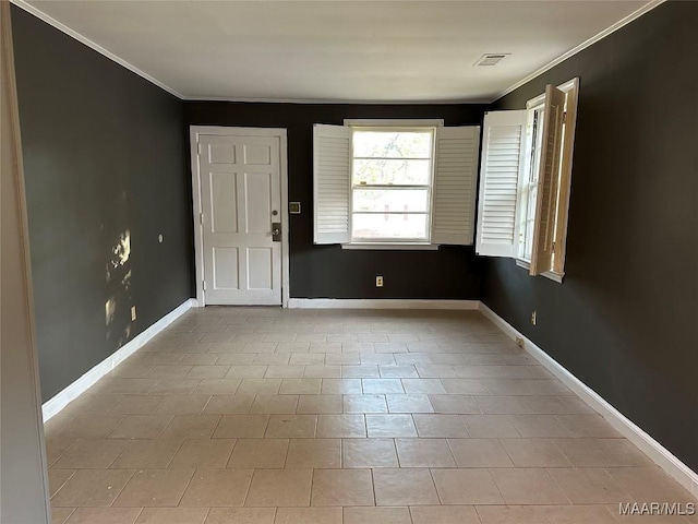 tiled empty room featuring crown molding