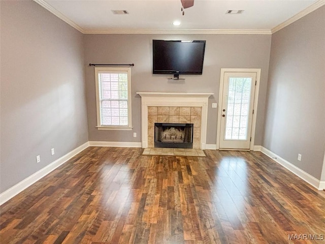 unfurnished living room featuring a tiled fireplace, ceiling fan, dark hardwood / wood-style flooring, and ornamental molding