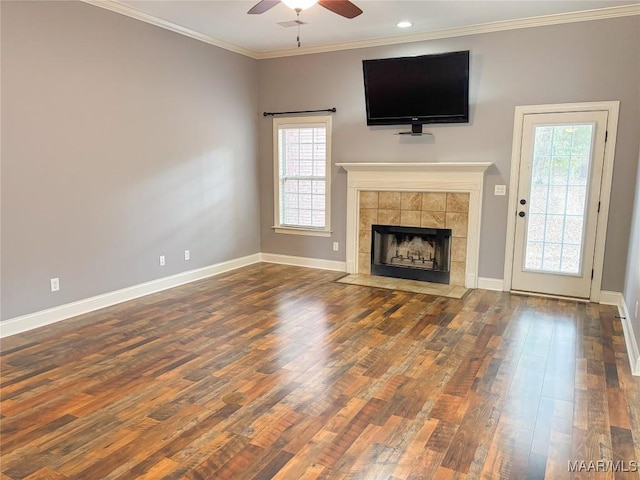 unfurnished living room featuring a tile fireplace, crown molding, ceiling fan, and hardwood / wood-style flooring