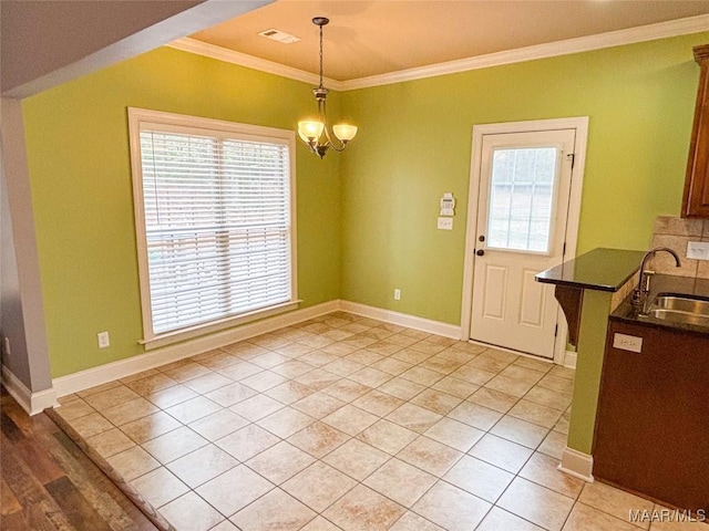 unfurnished dining area featuring sink, light tile patterned floors, a chandelier, and ornamental molding