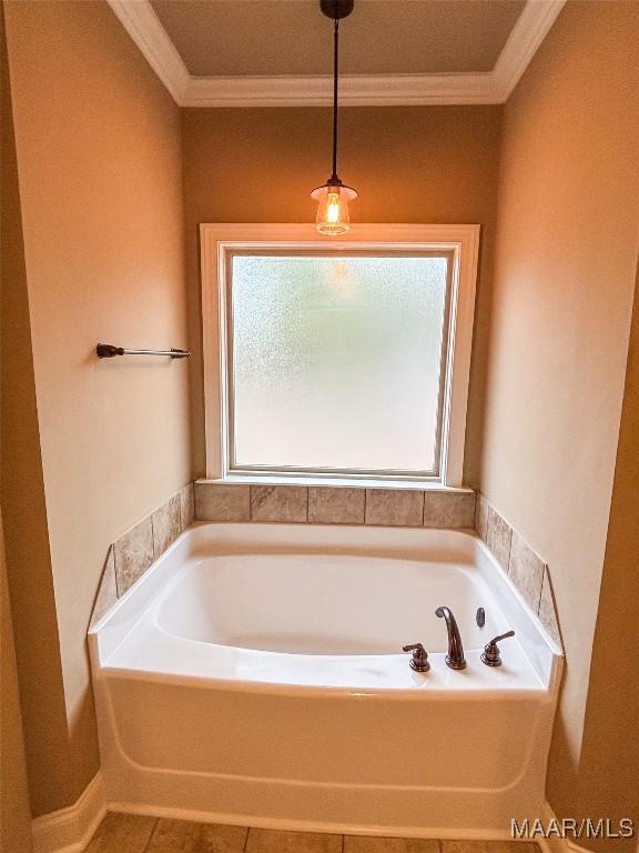 bathroom with tile patterned floors, a washtub, and crown molding