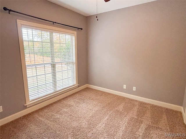 carpeted empty room featuring ceiling fan