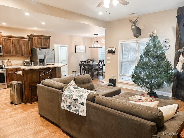 living room featuring light wood-type flooring and ceiling fan