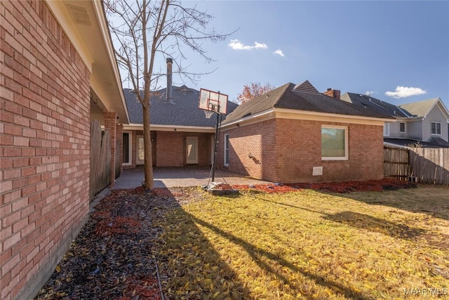 back of property with a patio area and a lawn