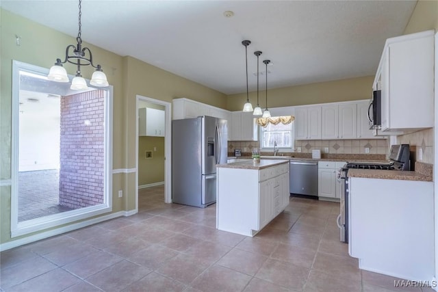 kitchen featuring a center island, white cabinetry, stainless steel appliances, and a chandelier